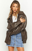 Faux leather oversized brown bomber jacket. Worn by model walking the street. 