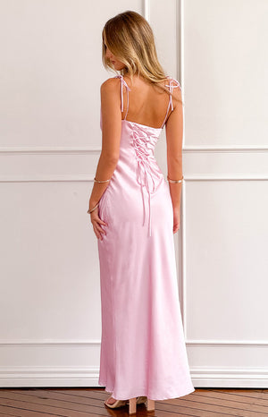 back shot of a blonde girl wearing a pink satin gown with tie back details styled with nude heels and silver bracelets