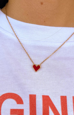 model is wearing a gold small red heart-shaped pendant necklace 