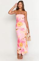 a blonde girl holding a drink is wearing a pink floral maxi dress and a gold necklace