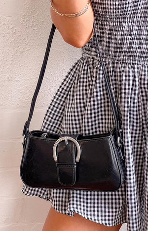 Black gingham dress and a black shoulder bag with silver hardware