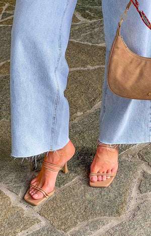 Light wash blue jeans and nude heels with brown handbag.