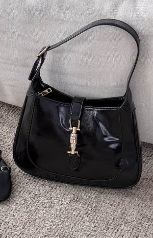 black patent shoulder bag with gold hardware clasp 