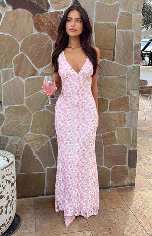 Pink lace floral maxi dress on brunette model holding a pink drink.