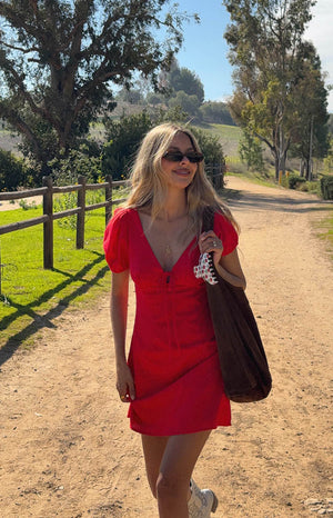 model is wearing a red mini dress with short puff sleeves and front tie-up