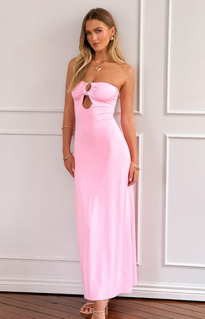 blonde model wearing a strapless pink maxi dress with ring detail at bust, paired with nude heels and gold jewellery