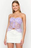 Girl smiling in purple sequin top and white denim skirt.