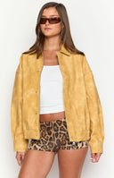 blonde model wearing a yellow suede jacket with a white tank, brown leopard sequin micro shorts and brown sunglasses