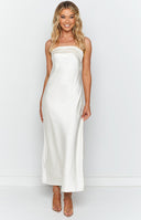 White strapless maxi dress worn by brunette model with white beaded necklace, gold necklace and nude heels.