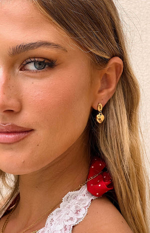 model wearing a thick gold heart stud dangle earrings