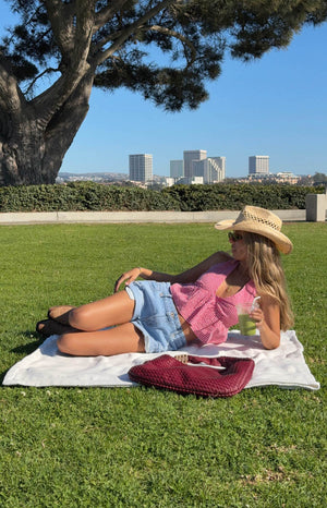 model wearing red gingham halter crop top with light wash denim shorts