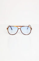 brunette model wearing brown tortoiseshell frame aviator sunnies with light blue grey lenses