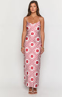 Model wearing red and white print maxi dress and red heels holding wine glass.