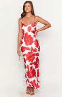 brunette model wearing a white and red floral maxi dress paired with white strappy heels and gold jewellery