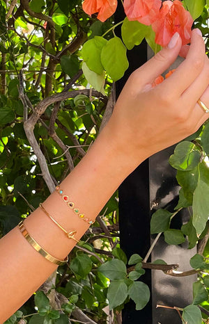 girl wearing three gold bracelets and a gold ring