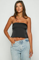 A brunette model is wearing a black, satin, strapless top. The model is showcasing the crop tops tie up back detailing, with its open back on show. 