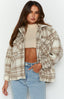 Brunette Model is posed in relaxed clothing, featuring a Checkered Fleece Jacket. The colour-way of jacket is neutrals, with cream and brown. Jacket is an oversized fit, with pockets on the front and buttons on middle seam for closure.